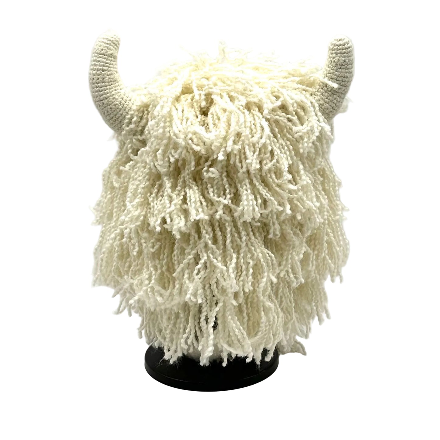 Knitted yeti head with long white fur and small horns on a white background