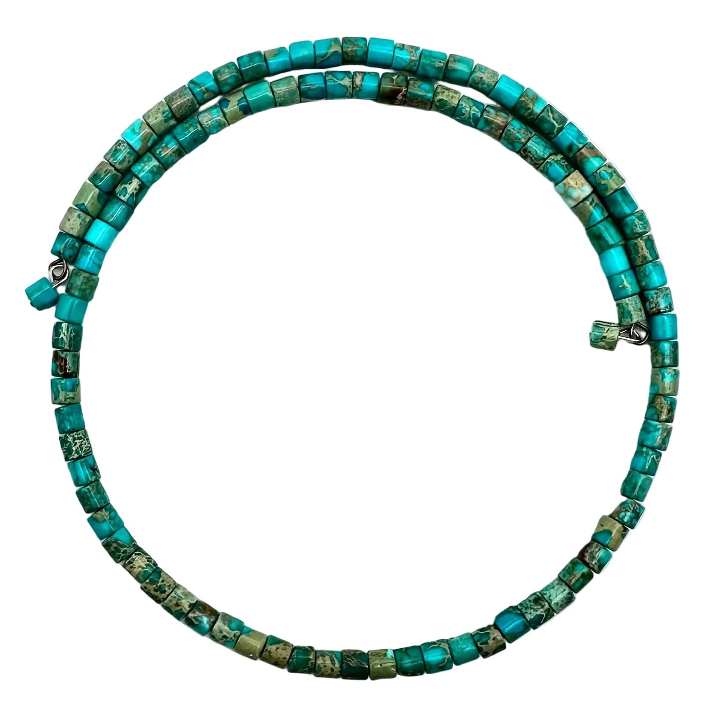 A beaded necklace made of small rectangular turquoise and green stone beads, arranged in a large circle on a plain white background.