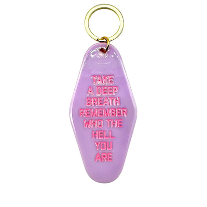 Purple keychain with pink text on a white background