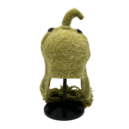 Green textured object on a black stand against a white background