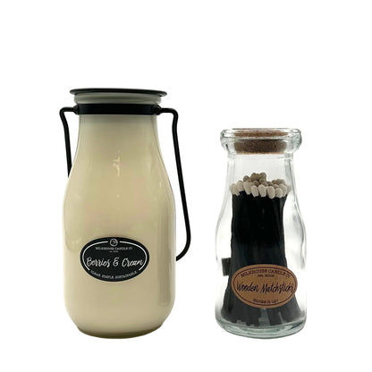 Two glass bottles, one with a candle labeled 'Berries & Cream' and the other with matches labeled 'Wooden Matchsticks', on a white background.