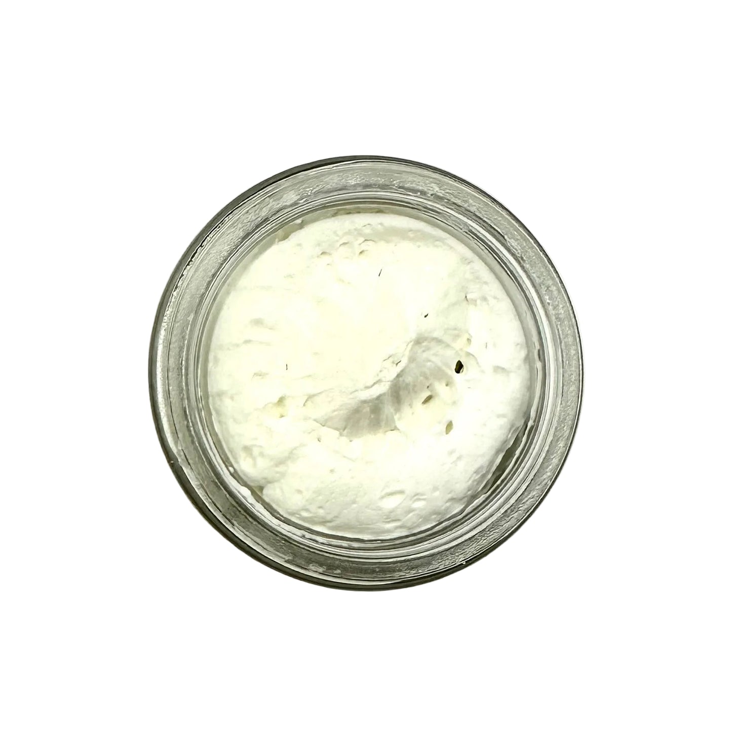 Small glass jar filled with a white creamy substance on a white background