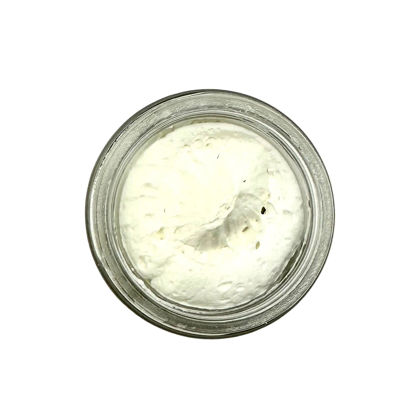 Small glass jar filled with a white creamy substance on a white background