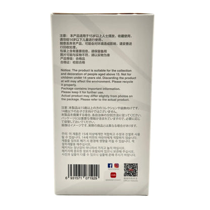 The back of a white rectangular product box with printed English and Chinese safety/usage information, a barcode, and small social media icons, photographed against a light gray background.